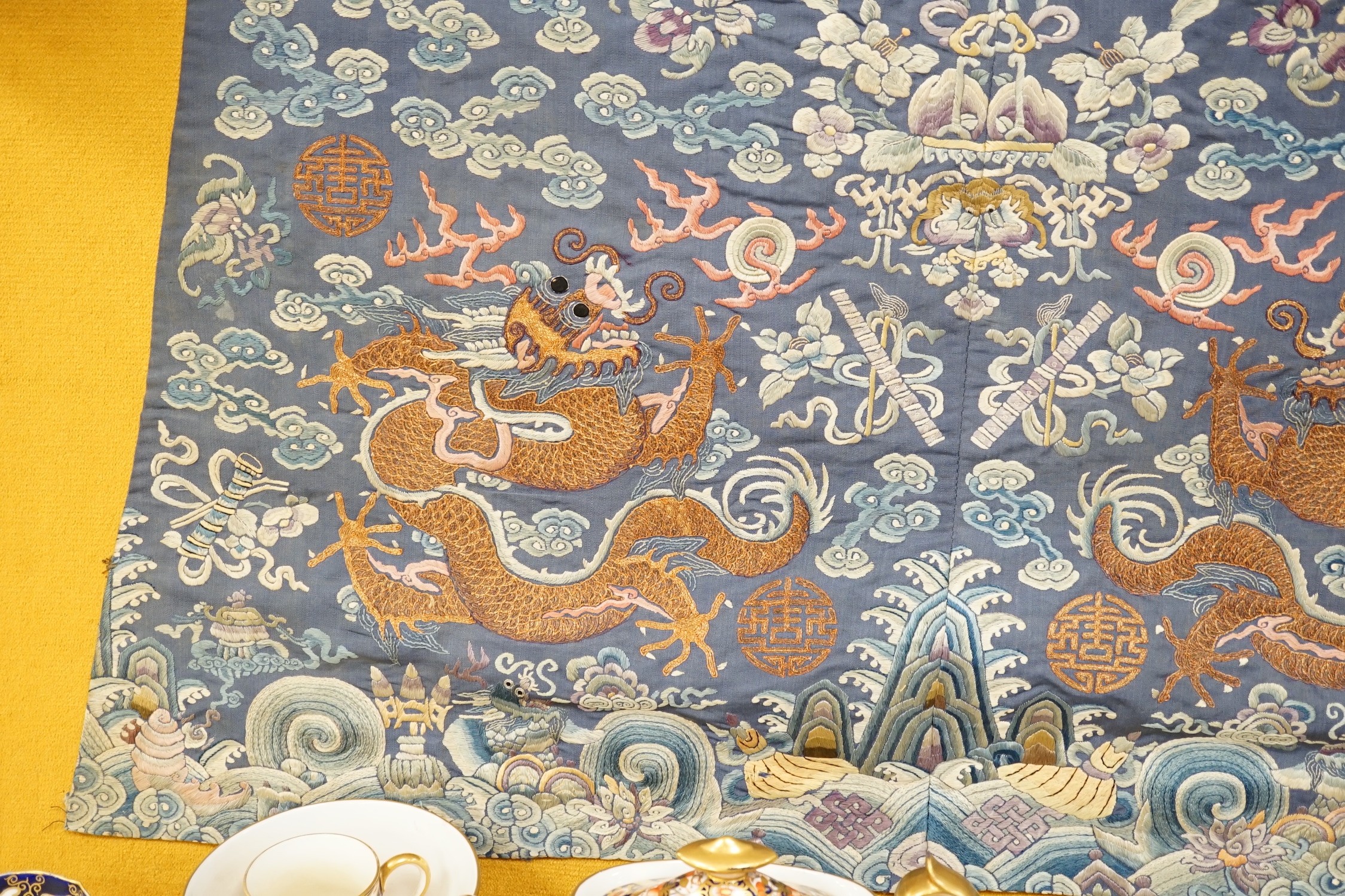 An early 20th century Chinese silk embroidered panel, from a robe, embroidered in metallic and coloured threads as dragons and auspicious symbols